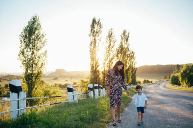 Huysuz anne ve yakışıklı oğul doğada eğleniyor. Mutlu aile kavramı. Aile hayatı olan güzel doğa manzarası. Mutlu bir aile birlikte dinleniyor. Aile yaşamında mutluluk. Anneler Günü.