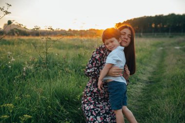 Huysuz anne ve yakışıklı oğul doğada eğleniyor. Mutlu aile kavramı. Aile hayatı olan güzel doğa manzarası. Mutlu bir aile birlikte dinleniyor. Aile yaşamında mutluluk. Anneler Günü.