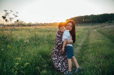 Huysuz anne ve yakışıklı oğul doğada eğleniyor. Mutlu aile kavramı. Aile hayatı olan güzel doğa manzarası. Mutlu bir aile birlikte dinleniyor. Aile yaşamında mutluluk. Anneler Günü.