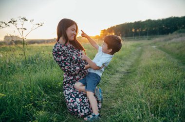 Huysuz anne ve yakışıklı oğul doğada eğleniyor. Mutlu aile kavramı. Aile hayatı olan güzel doğa manzarası. Mutlu bir aile birlikte dinleniyor. Aile yaşamında mutluluk. Anneler Günü.