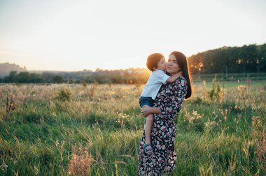 Huysuz anne ve yakışıklı oğul doğada eğleniyor. Mutlu aile kavramı. Aile hayatı olan güzel doğa manzarası. Mutlu bir aile birlikte dinleniyor. Aile yaşamında mutluluk. Anneler Günü.
