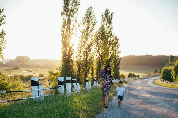 Stilish mother and handsome son having fun on the nature. Happy family concept. Beauty nature scene with family outdoor lifestyle. Happy family resting together. Happiness in family life. Mothers day.