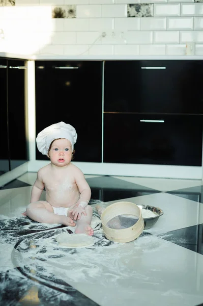 小男孩坐在厨房的地毯上玩炊具 可爱的男孩在家厨房里做饭 — 图库照片