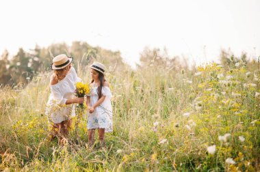 Şık bir anne ve güzel bir kız doğada eğleniyor. Mutlu aile kavramı. Aile hayatı olan güzel doğa manzarası. Aile birlikte dinleniyor. Aile yaşamında mutluluk. Anneler Günü