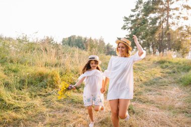 Anne ve kızı parkta eğleniyor. Aile yaşamında mutluluk ve uyum. Aile hayatı olan güzel doğa manzarası..