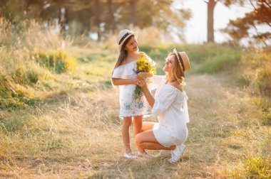 Anne ve kızı parkta eğleniyor. Aile yaşamında mutluluk ve uyum. Aile hayatı olan güzel doğa manzarası..