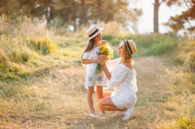 Anne ve kızı parkta eğleniyor. Aile yaşamında mutluluk ve uyum. Aile hayatı olan güzel doğa manzarası..