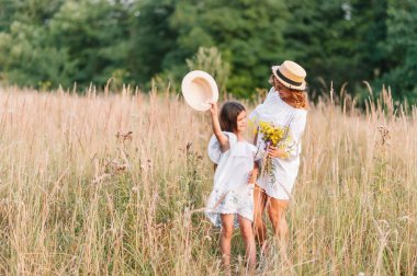 Anne ve kızı parkta eğleniyor. Aile yaşamında mutluluk ve uyum. Aile hayatı olan güzel doğa manzarası..