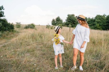 Anne ve kızı parkta eğleniyor. Aile yaşamında mutluluk ve uyum. Aile hayatı olan güzel doğa manzarası..