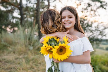 Anne ve kızı parkta eğleniyor. Aile yaşamında mutluluk ve uyum. Aile hayatı olan güzel doğa manzarası..