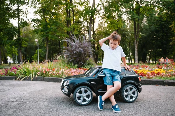 Aranyos Fiú Fekete Elektromos Autóval Parkban Vicces Fiú Egy Játék — Stock Fotó