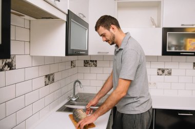 Evdeki mutfakta taze balık kesen adam. Adam aşçı için balık kesiyor.