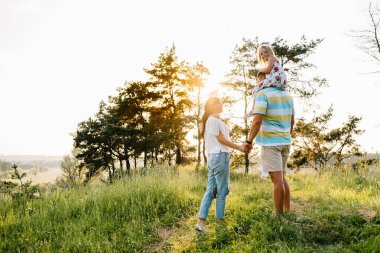 Mutlu aile kavramı - baba, anne ve çocuk eğleniyor ve doğada oynuyor..