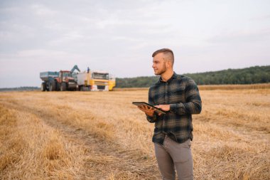 Hasattan sonra buğday tarlasında duran mutlu çiftçi. Tarım kavramı