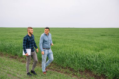 İki çiftçi tarlada buğday hasadını inceliyor..