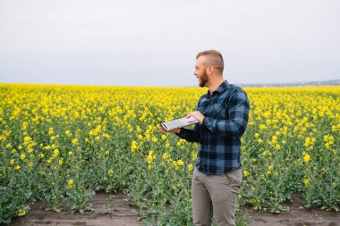 Tecavüz alanında genç bir tarım uzmanı. Tarım sektörü konsepti. Tecavüz alanında duran tarım mühendisi
