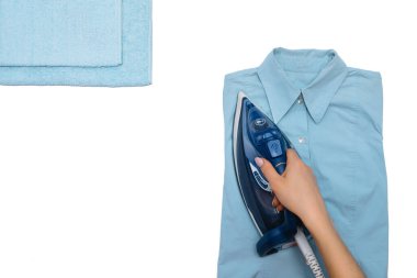 Kadın el ütüleme giysileri beyaz arka planda izole üst görünüm. Demiri ütüleyen adamın gömleğini giyen genç bir kadın ev işi sırasında yukarıdan görülmüş. Mavi ütü beyaz masada..