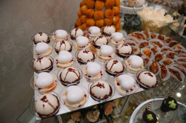 Meyveli tatlılar, krema, bisküvi. Farklı tatlı hamur işleri, küçük renkli tatlı kekler, makaron ve tatlı büfedeki diğer tatlılar. Doğum günü için çikolata.