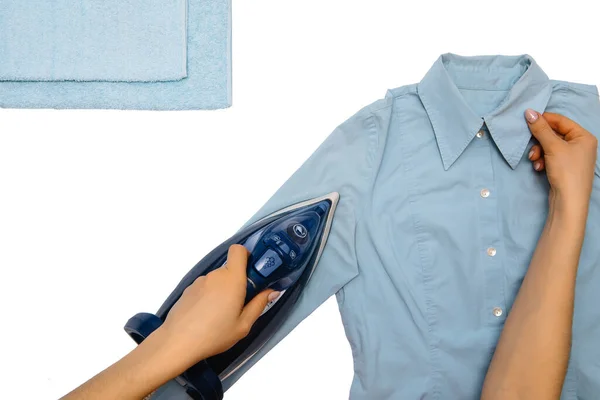 白い背景に隔離された女性の手のアイロンの服の上のビュー 家事中に上から見たアイロンアイロンの男のシャツを着た若い女性 白いテーブルの上の青鉄 — ストック写真
