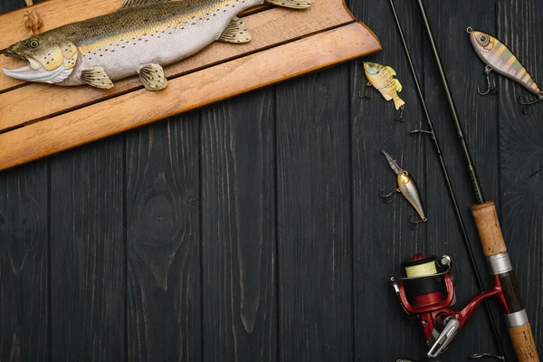 Fishing tackle - fishing spinning, hooks and lures on darken wooden  background. Top view. - Stock Image - Everypixel