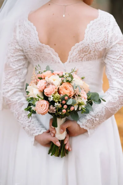 花嫁は花束と白いウェディングドレスに立っています — ストック写真