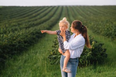 Stilish anne ve kızı doğada eğleniyorlar. Mutlu aile kavramı. Aile hayatı olan güzel doğa manzarası. Mutlu bir aile birlikte dinleniyor. Aile yaşamında mutluluk. Anneler Günü.