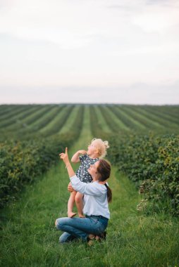 Stilish anne ve kızı doğada eğleniyorlar. Mutlu aile kavramı. Aile hayatı olan güzel doğa manzarası. Mutlu bir aile birlikte dinleniyor. Aile yaşamında mutluluk. Anneler Günü.