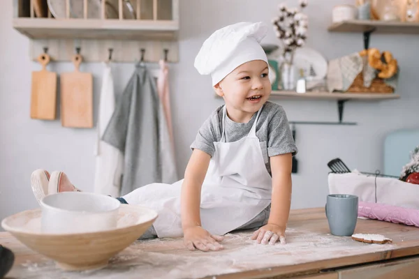 Молодий Хлопчик Симпатичний Кухні Кухар Білій Формі Капелюсі Біля Столу — стокове фото