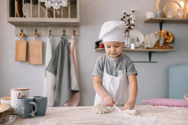 Молодий Хлопчик Симпатичний Кухні Кухар Білій Формі Капелюсі Біля Столу — стокове фото