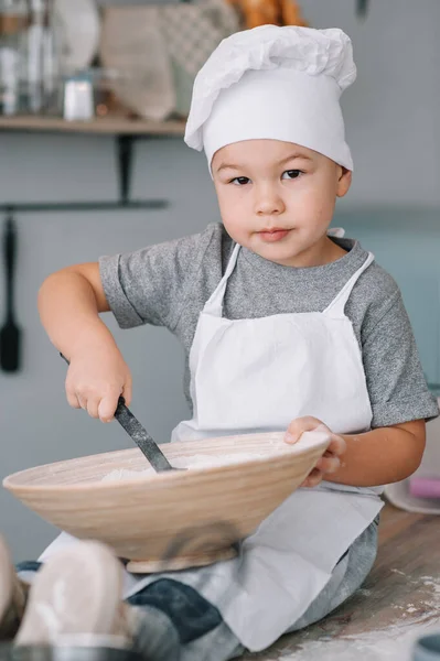 Menino Bonito Cozinha Cozinheiro Chef Uniforme Branco Chapéu Perto Mesa — Fotografia de Stock