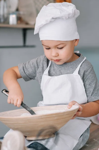 Menino Bonito Cozinha Cozinheiro Chef Uniforme Branco Chapéu Perto Mesa — Fotografia de Stock