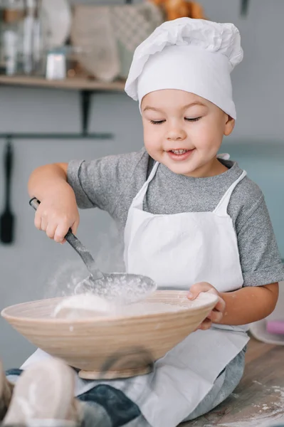 Молодий Хлопчик Симпатичний Кухні Кухар Білій Формі Капелюсі Біля Столу — стокове фото