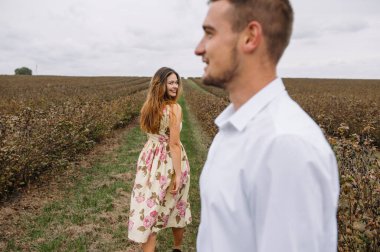 Bir kız ve bir erkek doğada yürüyorlar. Bir çiftin portresi, bir aşk hikayesi. Mutlu gülümseyen, sevgi dolu bir çift, güzel doğada uzanıyorlar. Aşk hikayesi.