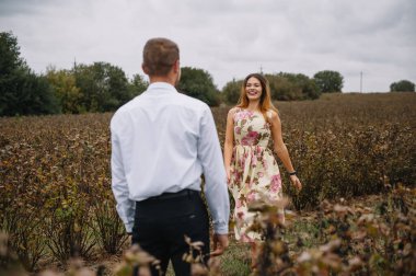 Bir kız ve bir erkek doğada yürüyorlar. Bir çiftin portresi, bir aşk hikayesi. Mutlu gülümseyen, sevgi dolu bir çift, güzel doğada uzanıyorlar. Aşk hikayesi.