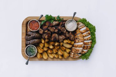 Çoğu et yemeği - sığır kebabı, sosis, mantar, patates, domates ve sos. Bira için en iyi seçim. Beyaz arkaplanda yakın plan.