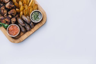 Çoğu et yemeği - sığır kebabı, sosis, mantar, patates, domates ve sos. Bira için en iyi seçim. Beyaz arkaplanda yakın plan.