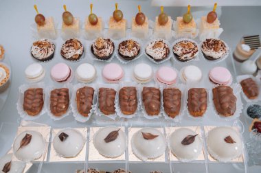 Taze, egzotik, organik meyveler, açık büfe masasında hafif atıştırmalıklar. Mini yemekler, abur cuburlar, etkinliklerde restoran yemekleri. Parti malzemeleri için dekore edilmiş nefis bir masa. Kekler ve brovniler açık büfe masasının üzerinde duruyor.