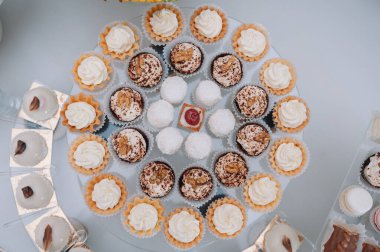 Taze, egzotik, organik meyveler, açık büfe masasında hafif atıştırmalıklar. Mini yemekler, abur cuburlar, etkinliklerde restoran yemekleri. Parti malzemeleri için dekore edilmiş nefis bir masa. Kekler ve brovniler açık büfe masasının üzerinde duruyor.