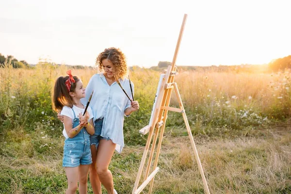 阳光明媚的大自然 妈妈和女儿在公园里画了一幅画 画了一个小孩 一个孩子的创造力 母亲节 — 图库照片