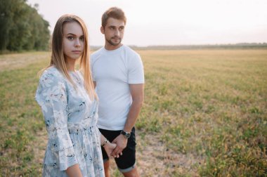 Bir kız ve bir erkek parkta yürüyorlar. Bir çiftin portresi, bir aşk hikayesi. Mutlu gülümseyen, sevgi dolu bir çift, güzel doğayla iç içe. Sevimli.