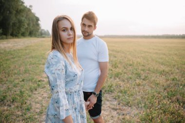 Bir kız ve bir erkek parkta yürüyorlar. Bir çiftin portresi, bir aşk hikayesi. Mutlu gülümseyen, sevgi dolu bir çift, güzel doğayla iç içe. Sevimli.