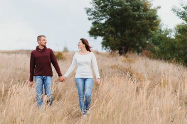 Güz parkında yürüyen güzel genç bir çift