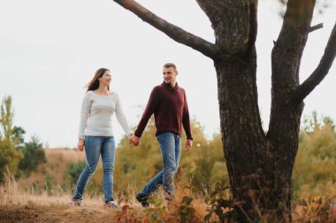 Güz parkında yürüyen güzel genç bir çift