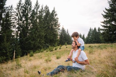 Mutlu baba ve küçük çocuk dağlarda yürüyorlar. Babalar Günü. Ulusal parkta tatil