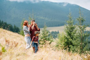Dağda dinlenen çocuklu genç bir aile.