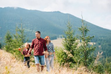 Dağda dinlenen çocuklu genç bir aile.