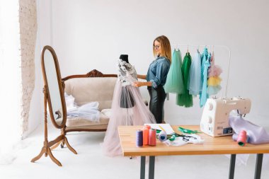Herhangi bir hata yapamam. Kadın moda tasarımcısı atölyedeki yeni kıyafetler üzerinde çalışıyor..