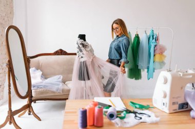 Mutlu genç moda deisgner stüdyosunda. terzilik konsepti