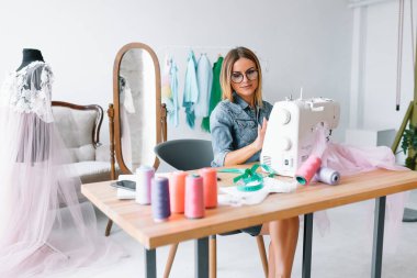 Yeni koleksiyon üzerinde çalışıyorum. Yeni düzen. Kadın moda tasarımcısı atölyedeki yeni kıyafetler üzerinde çalışıyor..