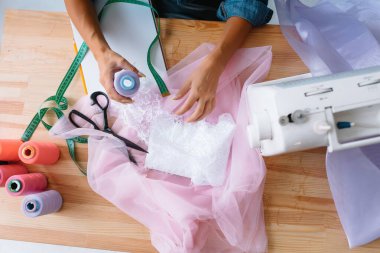 Bayan terzi çok güzel, şık kıyafetler dikmiş. Şablonun çapraz bağlama kısımları. İş yeri. Üst Manzara. Hafif Tekstil Endüstrisi yaratıcı anları